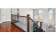 Beautiful railing and chandelier in an open hallway overlooking a view of the front door at 16101 Iola St, Brighton, CO 80602