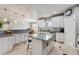 Spacious kitchen with white cabinets, granite countertops, central island, and tile flooring at 16101 Iola St, Brighton, CO 80602