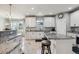 Bright kitchen with white cabinets, granite countertops, a center island, and a breakfast bar at 16101 Iola St, Brighton, CO 80602