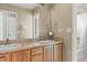 Double sink bathroom featuring warm wood cabinets and a large mirror at 15021 Josephine St, Thornton, CO 80602