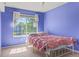 A bedroom with a neutral carpet, a window, and bright lavender colored walls at 15021 Josephine St, Thornton, CO 80602