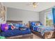 This bedroom features two beds, a ceiling fan, and a window for natural light at 15021 Josephine St, Thornton, CO 80602