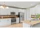 Bright kitchen features stainless steel appliances, white cabinets and tile backsplash at 15021 Josephine St, Thornton, CO 80602