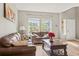 Cozy living room with hardwood floors, two large windows and leather sofas at 15021 Josephine St, Thornton, CO 80602