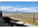 Expansive backyard view with rolling hills and distant mountain views under a blue sky with scattered clouds at 4742 Raven Run, Broomfield, CO 80023