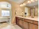 Bathroom with dual vanity sinks, a large mirror, and a tub/shower combo at 4742 Raven Run, Broomfield, CO 80023