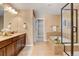 Bathroom with dual vanity sinks, a large mirror, and a tub/shower combo at 4742 Raven Run, Broomfield, CO 80023