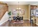 Bright dining room with hardwood floors, modern chandelier, and kitchen with breakfast bar at 4742 Raven Run, Broomfield, CO 80023