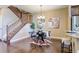 Bright dining room with hardwood floors, modern chandelier, and staircase at 4742 Raven Run, Broomfield, CO 80023