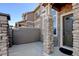 Inviting entryway with stone pillar and gated front patio at 4742 Raven Run, Broomfield, CO 80023