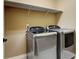 Spacious laundry room with modern washer and dryer units and overhead shelving at 4742 Raven Run, Broomfield, CO 80023