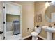 Convenient half bathroom featuring in-unit laundry setup and pedestal sink at 4742 Raven Run, Broomfield, CO 80023