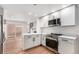 Stylish kitchen with stainless steel appliances, white cabinets, quartz countertops, and spiral staircase at 11820 Lincoln St, Northglenn, CO 80233