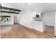 Open-concept living area featuring hardwood floors, exposed beams, and a breakfast bar at 11820 Lincoln St, Northglenn, CO 80233