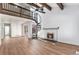 Spacious living room boasts a cozy fireplace, exposed beams, and spiral staircase leading to a loft at 11820 Lincoln St, Northglenn, CO 80233