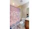 Cozy bathroom featuring a toilet, shower with a floral curtain, neutral wall color and decorative accessories at 9994 Quintero St, Commerce City, CO 80022