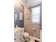 This half-bathroom features modern fixtures, a white vanity with black handles, and stylish wall art at 9994 Quintero St, Commerce City, CO 80022