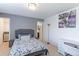 The bedroom offers a calm atmosphere with a gray bed, a white desk, and soft carpet at 9994 Quintero St, Commerce City, CO 80022