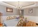 The dining room is decorated with neutral tones, and lit by a chandelier over the dining table at 9994 Quintero St, Commerce City, CO 80022