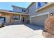 Home featuring a manicured lawn, covered porch, and an attached two-car garage at 9994 Quintero St, Commerce City, CO 80022