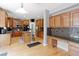 Spacious kitchen featuring light wood floors, cabinets, granite countertops, a central island, and a built-in desk area at 9994 Quintero St, Commerce City, CO 80022