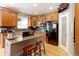 Kitchen island with gas range, granite countertops and wooden stools complements the stainless steel appliances and wood cabinets at 9994 Quintero St, Commerce City, CO 80022