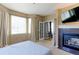 Cozy main bedroom featuring a fireplace, plush carpet, and ample natural light at 9994 Quintero St, Commerce City, CO 80022