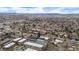 Aerial view of a neighborhood nestled among trees, with mountains in the distance on a cloudy day at 11455 W 17Th Pl, Lakewood, CO 80215