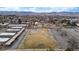 Overhead view showcasing an empty field, parking lot, and surrounding buildings in a suburban setting at 11455 W 17Th Pl, Lakewood, CO 80215