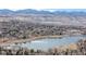 Picturesque aerial view overlooking a serene lake surrounded by lush trees and distant mountains at 11455 W 17Th Pl, Lakewood, CO 80215