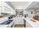 Bright kitchen with white cabinetry, modern appliances, and decorative backsplash and window treatment at 11455 W 17Th Pl, Lakewood, CO 80215