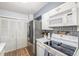 The kitchen features white cabinets, stainless steel refrigerator and unique tiled backsplash behind the stove at 11455 W 17Th Pl, Lakewood, CO 80215