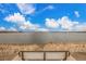 Lake view featuring a bench seat at the water's edge surrounded by reeds and a blue sky with clouds at 11455 W 17Th Pl, Lakewood, CO 80215