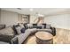 Open living room with a large sectional sofa, a coffee table, and a bar area near the stairs at 11455 W 17Th Pl, Lakewood, CO 80215