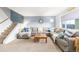 Cozy living room with plush carpet, a large sectional sofa, and a stylish accent wall at 11455 W 17Th Pl, Lakewood, CO 80215