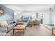 Bright living room with a large sectional sofa, a large window, and hardwood floors at 11455 W 17Th Pl, Lakewood, CO 80215