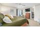 The main bedroom includes an ensuite bathroom, a ceiling fan, a TV, and neutral carpeting at 11455 W 17Th Pl, Lakewood, CO 80215