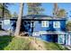 Blue home featuring lots of windows and natural rock formations on the property at 4642 Plettner Ln, Evergreen, CO 80439