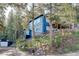 Exterior elevation of the blue home featuring a well-manicured, natural landscape at 4642 Plettner Ln, Evergreen, CO 80439