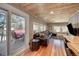 Spacious living room with hardwood floors, wood ceiling, and sliding glass door to deck at 4642 Plettner Ln, Evergreen, CO 80439