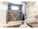 Bathroom showcasing bathtub with decorative glass block detail and tiled walls at 4392 E 126Th Pl, Thornton, CO 80241