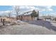 View of the brick home with a gravel driveway, fire pit, and well-maintained landscaping at 767 Ellis St, Golden, CO 80401