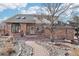 Charming brick home with a landscaped walkway leading to the entrance, mature trees, and great curb appeal at 767 Ellis St, Golden, CO 80401