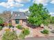 Landscaped front yard features a brick pathway, lush garden beds, and a mature tree creating a welcoming curb appeal at 767 Ellis St, Golden, CO 80401