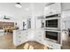 Modern kitchen with white cabinets, stainless appliances, and open to the dining area at 767 Ellis St, Golden, CO 80401