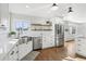 Bright kitchen features stainless steel appliances, farmhouse sink, open shelving, and gleaming hardwood floors at 767 Ellis St, Golden, CO 80401