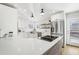 Modern kitchen featuring white cabinets, a stainless steel sink, and stone countertops at 767 Ellis St, Golden, CO 80401