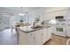 Open kitchen with an island, white appliances, and granite countertops, perfect for entertaining at 16159 W 70Th Pl, Arvada, CO 80007