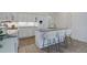Modern kitchen with an island, bar stool seating, granite countertops, and white cabinetry at 16159 W 70Th Pl, Arvada, CO 80007