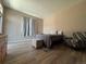 Bedroom with a queen size bed, wood floors, a black and white chair, and natural light at 9806 Hooker Ct, Westminster, CO 80031